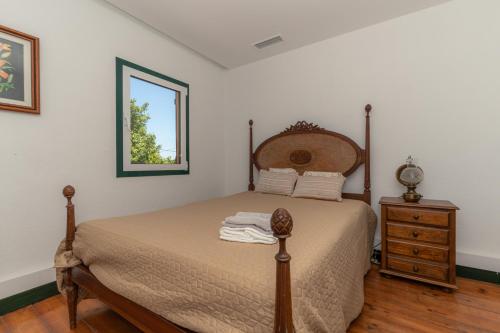 a bedroom with a bed and a dresser and a window at Atlantic Nest Poiares in Vila Nova de Poiares