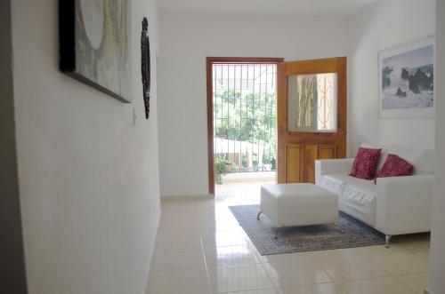 a living room with a white couch and a chair at Hotel las Nina in Paraíso