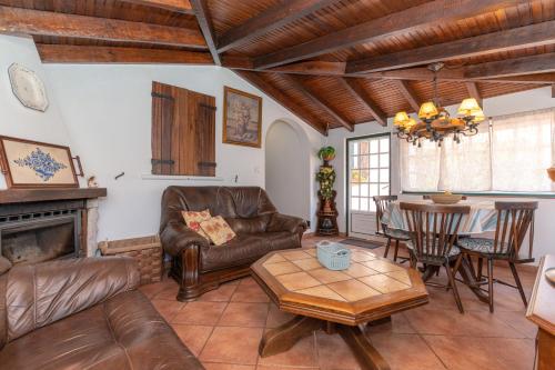 a living room with leather furniture and a table at Atlantic Nest Poiares in Vila Nova de Poiares