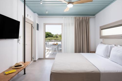 a hotel room with a bed and a balcony at Sourinis Luxury Suites in Limenaria