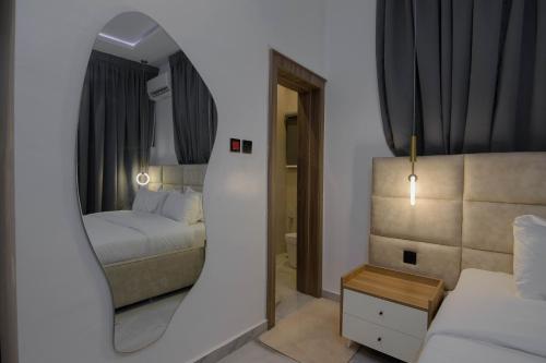 a mirror in a room with a bed and a bedroom at One90 Apartment in Lagos
