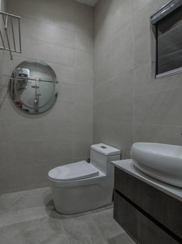 a bathroom with a toilet and a sink and a mirror at One90 Apartment in Lagos