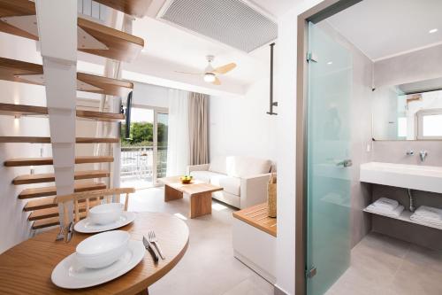 a living room with a table and a bathroom at Sourinis Luxury Suites in Limenaria