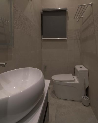 a bathroom with a white sink and a toilet at One90 Apartment in Lagos