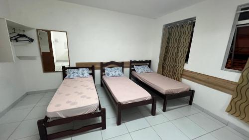 a room with two beds and a mirror at Apartamento triplo centro in Campina Grande