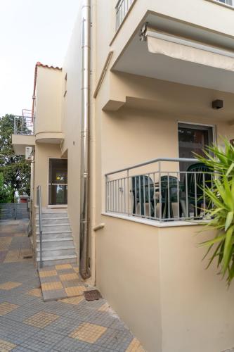 a building with a balcony with chairs on it at Comfortable 3-Bedroom Maisonette Near the Sea in Mytilini