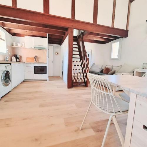 une cuisine avec une table et une chaise dans une pièce dans l'établissement Maisonnette proche océan, à Lacanau