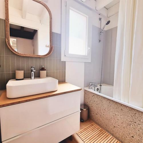 une salle de bain avec un lavabo blanc et un miroir dans l'établissement Maisonnette proche océan, à Lacanau