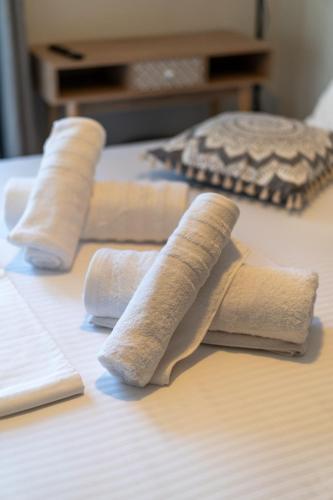 a group of four pillows sitting on a bed at Comfortable 3-Bedroom Maisonette Near the Sea in Mytilini