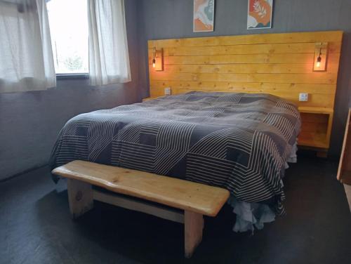 a bed with a wooden headboard and a wooden bench at Tierras Mágicas in Villa Pehuenia