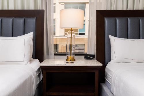 a bedroom with two beds and a table with a lamp at DoubleTree by Hilton Houston Medical Center Hotel & Suites in Houston