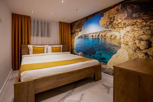 a bedroom with a wall mural of the ocean at Bentley Apartments in Pristina