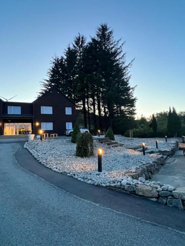 un vialetto di ghiaia con candele davanti a un edificio di Selvbetjent leilighetshotell på Ålgård ad Ålgård