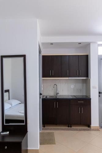 a kitchen with a mirror and a sink and a bed at Villa Hamza Ksamil in Ksamil