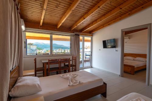 a bedroom with a bed and a balcony with a table at Villa Hamza Ksamil in Ksamil