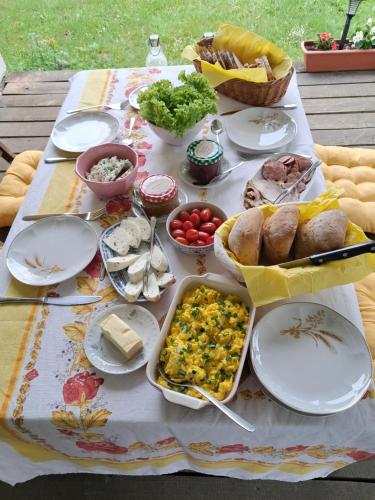 a table with plates of food on a table at Agroturystyka Nasza Bajka in Pieniężno
