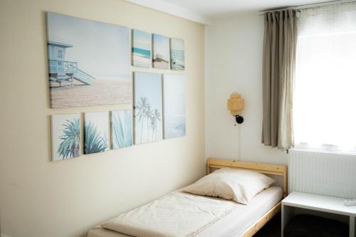 a bed in a room with pictures on the wall at Anca's Haus in Schwanstetten