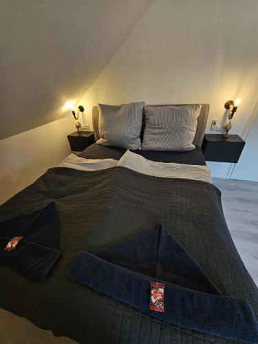 a large bed with a black comforter in a room at Tautraum Suite mit Whirlpool und grünem Ausblick in Wilhelmshaven