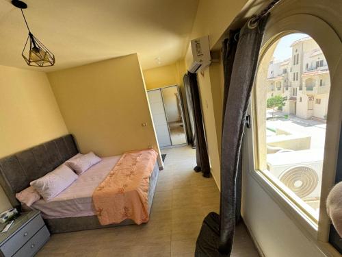a small bedroom with a bed and a window at Lasirena north coast Chalet With Roof , 3 rooms in Zāwiyat ‘Abd al Mun‘im