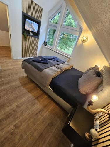 a large bed in a room with two windows at Tautraum Suite mit Whirlpool und grünem Ausblick in Wilhelmshaven