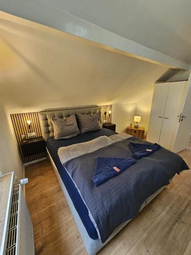 a bedroom with a large bed with a blue blanket at Tautraum Suite mit Whirlpool und grünem Ausblick in Wilhelmshaven