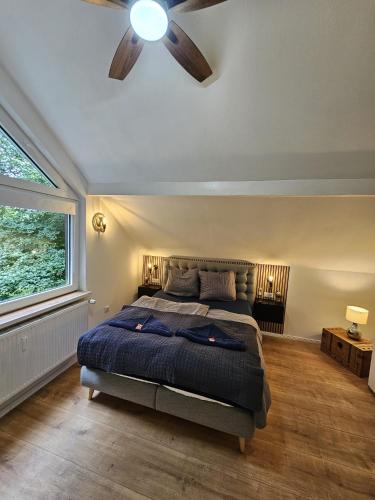a bedroom with a bed and a ceiling fan at Tautraum Suite mit Whirlpool und grünem Ausblick in Wilhelmshaven