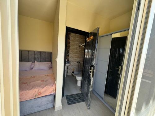 a bedroom with a bed and a bathroom with a toilet at Lasirena north coast Chalet With Roof , 3 rooms in Zāwiyat ‘Abd al Mun‘im