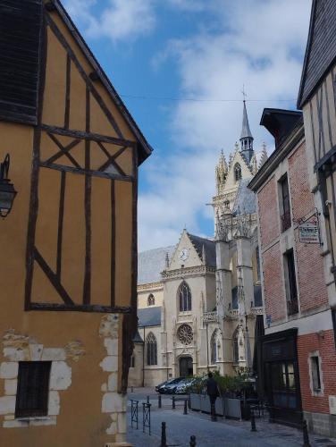 un bâtiment avec une tour d'horloge et une église dans l'établissement Studio atypique, à La Ferté-Bernard