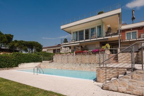 a house with a swimming pool in front of a house at Timetofreedom Apartment Bellevue in Bardolino