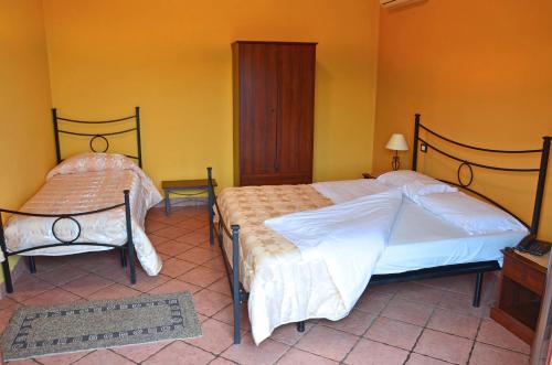 ニコロージにあるB&B La Porta Dell'Etna - Nicolosiのベッドルーム1室(ツインベッド2台、テーブル付)