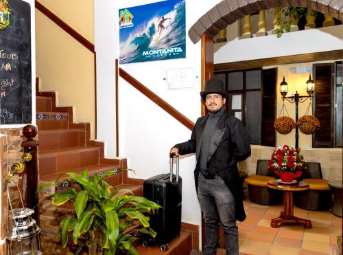 a man standing in a lobby with a suitcase at Friends Hotel & Rooftop - Historic Center & Museums in Quito