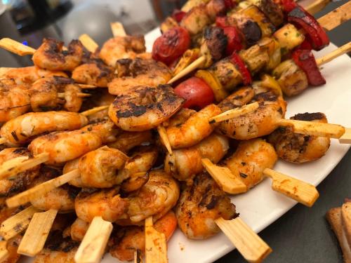 a plate of food with shrimp and vegetables on skewers at Demeure Sainte Clotilde, événementiel et chambres d'hôtes à Neffies in Néffiès