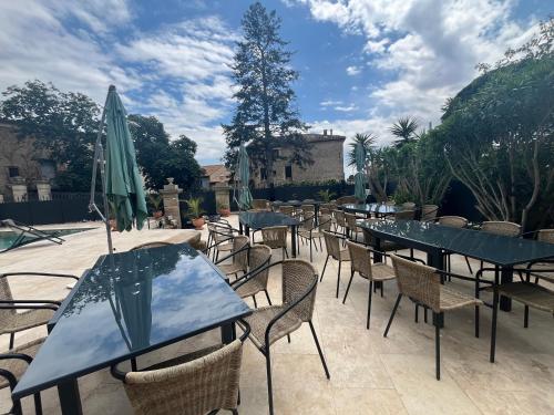 a row of tables and chairs with umbrellas at Demeure Sainte Clotilde, événementiel et chambres d'hôtes à Neffies in Néffiès