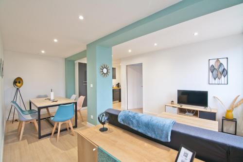 un salon avec un canapé bleu et une salle à manger dans l'établissement Appartement familial, 2 chambres, en RdC sur cour, à Saint-Florentin