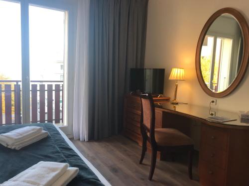 a bedroom with a desk and a mirror and a bed at Hotel Le Bourgogne in Évian-les-Bains