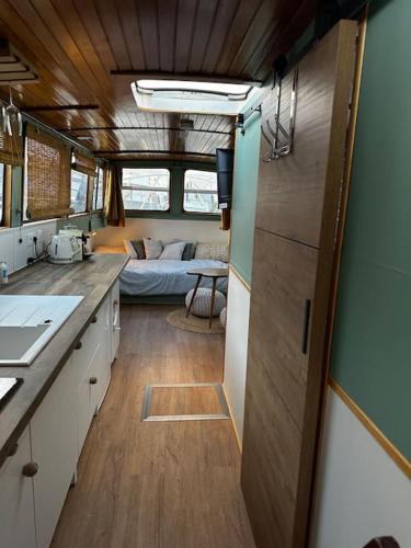 Il comprend une cuisine et un salon avec un lit. dans l'établissement Péniche cocoun, à Valence