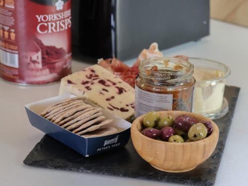 a table with a bowl of grapes and a jar of cheese at Heron in Carnforth