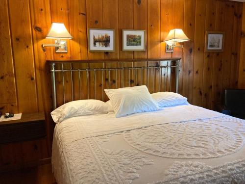 a bedroom with a large bed with wooden walls at Ludington Blue Spruce Inn in Ludington