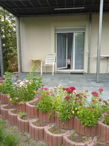 a garden with flowers and a table on a patio at Hotel Konty in Kąty Opolskie