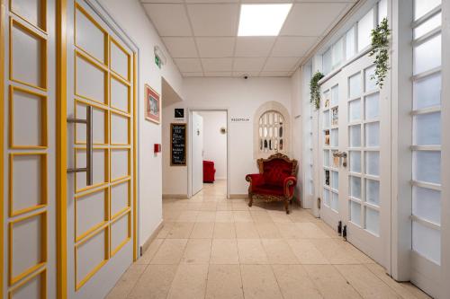 a corridor with a red chair in a hallway at Bed & Breakfast Blanc in Pučišća