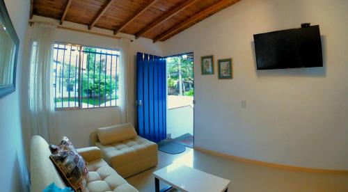 a living room with a couch and a flat screen tv at Azulejo - Guest House in Medellín