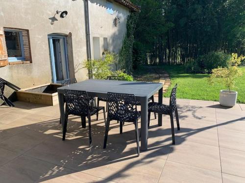 a black table and chairs on a patio at Logis Groly gîte avec spa en campagne proche Montauban in Genébrières