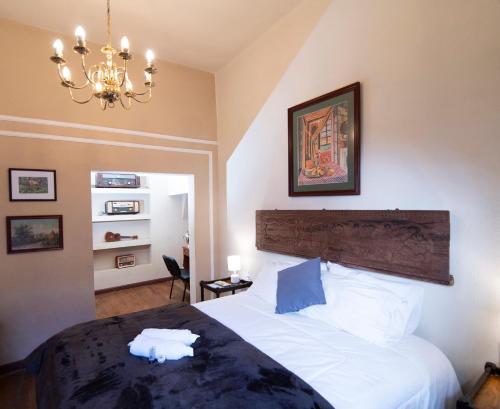 a bedroom with a large bed and a chandelier at Anami Hotel Boutique in La Paz