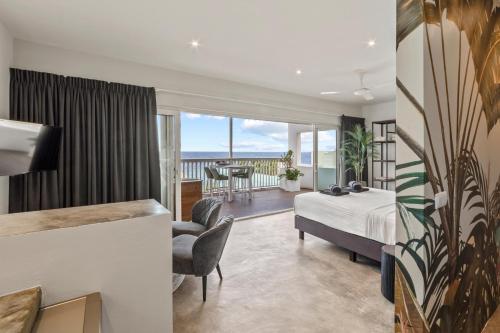 a hotel room with a bed and a balcony at PM78 Boutique Apartments in Willemstad