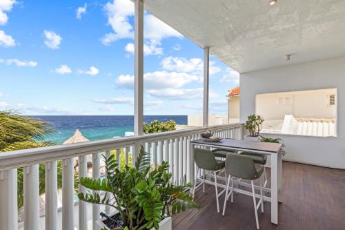 a balcony with a table and chairs and the ocean at PM78 Boutique Apartments in Willemstad