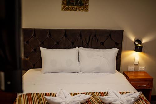 a bedroom with a bed with two white flowers on it at Santuario Machupicchu in Machu Picchu
