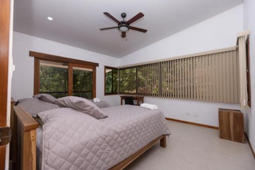 a bedroom with a bed and a ceiling fan at Casa Kabuae in Portalón