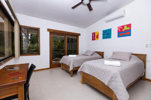 a bedroom with two beds and a desk at Casa Kabuae in Portalón