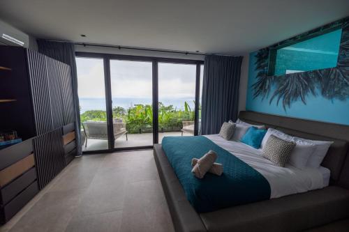 a bedroom with a bed with a teddy bear on it at Divinity Costa Rica All Inclusive Luxury Villa in Dominical