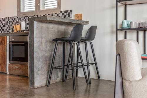 two bar stools in front of a kitchen counter at PM78 Boutique Apartments in Willemstad